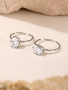 Close-up of silver-toned oval cubic zirconia rings with multi-prong setting on smooth band