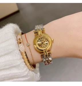 Close-up of a women's vintage gold steel watch with Roman numerals on a model's wrist