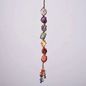 Detailed macro view of seven chakra natural stones in a brown hand-woven hanging ornament