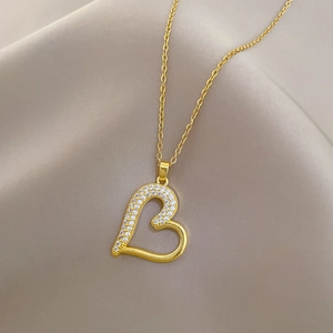 Detail of a gold heart pendant with sparkling crystals on a delicate chain necklace