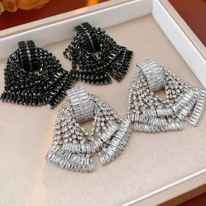Detailed close-up of bow tassel earrings with black and silver baguette crystals