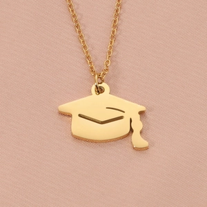 Detailed macro view of the gold graduation cap pendant on a delicate link chain necklace