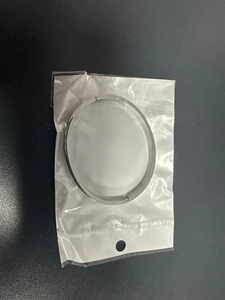Vista dettagliata di un bracciale in acciaio al titanio argento in una busta di plastica