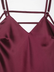 Detailed view of the burgundy satin midi dress with crisscross straps and V-neckline