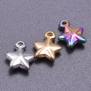 Macro shot of three star-shaped metal pendants in silver, gold, and rainbow finishes