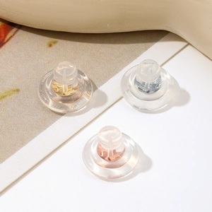 Macro detail of 18K gold and silver silicone earring backs in assorted metallic tones