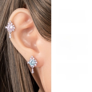 Detailed close-up of heart-and-arrow zircon cartilage stud earrings on a silicone model