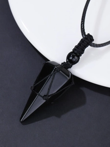 Detailed close-up of polished black obsidian hexagonal prism pendant on woven cord