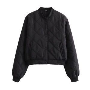 Détail d'une veste matelassée noire avec motif en losanges et poignets côtelés