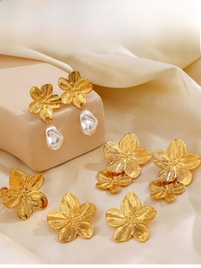 Detail of golden flower earrings with baroque pearls on a warm silk background