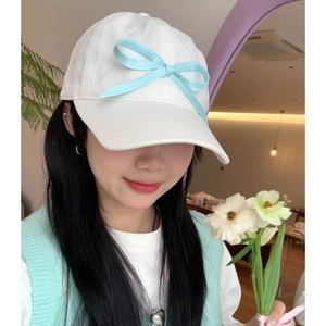 White baseball cap featuring a soft light blue ribbon bow for a sweet, preppy look