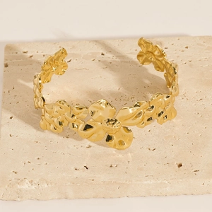 Detailed view of an 18K gold-plated C-shaped open cuff with 3D floral metal design