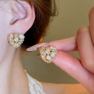 Macro detail of 18k gold plated heart earrings with sparkling cubic zirconia stones