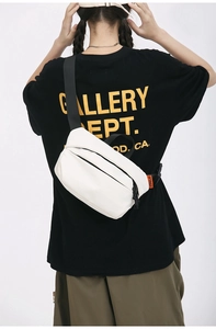 Close-up of white nylon crossbody bag with black adjustable strap worn by a male model