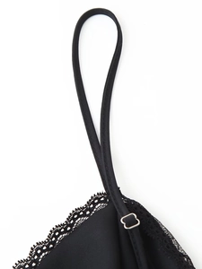 Close-up of black lace trim and adjustable metal slider on slim V-neck dress strap