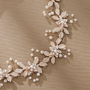 Elegant bridal floral headband with golden metal leaves, pearls and rhinestones on beige background