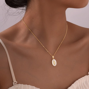 Gold oval pendant necklace for women with Virgin Mary relief on white shell background