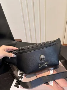 Black pebbled leather fanny pack with silver skull emblem and wide adjustable strap