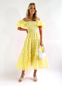 Detail of yellow plaid off-shoulder dress featuring puffy sleeves and textured fabric