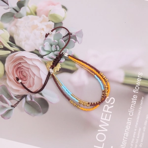 Close-up of handmade multi-layer beaded bracelet with woven adjustable cord