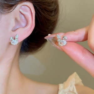 Macro detail of rabbit shaped stud earrings with sparkling cubic zirconia on ears