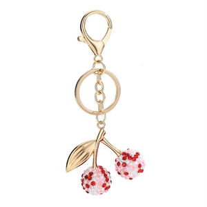 Porte-clés cerise scintillant avec strass en cristal et feuilles dorées sur fond blanc