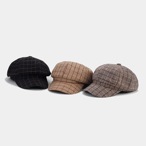 Detailed view of three vintage British style plaid newsboy caps in different colors