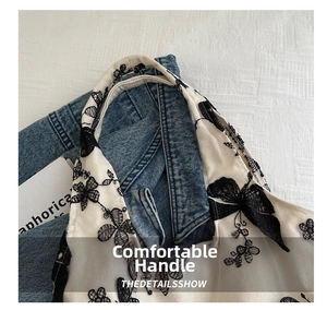 Close-up of comfortable handle with delicate black butterfly embroidery on white canvas bag
