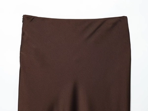 Gros plan sur la taille d'une jupe en satin marron avec fermeture éclair invisible et dentelle