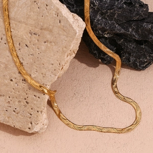 Detailed view of the 18K gold plated herringbone snake chain on decorative stones