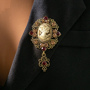 Detail of vintage relief cameo brooch with red rhinestones on a black suit lapel