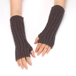 Detailed view of dark brown cable knit fingerless gloves showing textured patterns