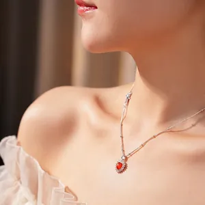 Vintage zircon heart pendant necklace with red gemstone worn by a model in soft light