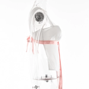 Seitenansicht eines weißen Camisole-Tops mit rosa Schnürung auf einer klaren Schaufensterpuppe