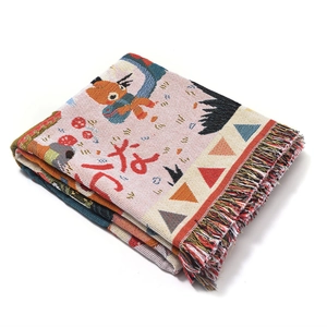 Detail of woven camping blanket with colorful bohemian patterns and fringe tassels