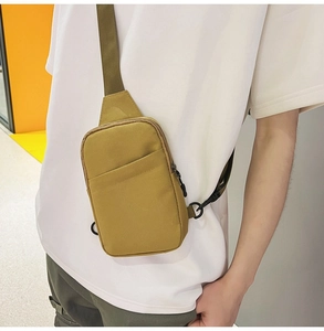 Close-up of khaki nylon chest bag with black buckle and adjustable shoulder strap