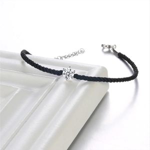 Macro shot of the black woven rope bracelet showing the single cubic zirconia and silver clasp