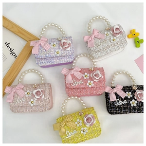 Detail of tweed children's handbags with pearl handles and decorative floral accents