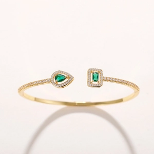 Adjustable gold cuff bracelet with pear and rectangular emerald cubic zirconia accents
