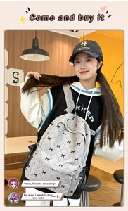 Detail of grey quilted backpack with ribbon bows shown in a cozy cafe setting
