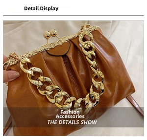 Detail of vintage brown kiss-lock handbag with ornate floral engraved metal frame