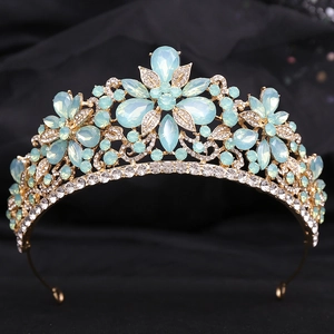 Detail of golden tiara with light blue crystal flowers and rhinestones on black silk