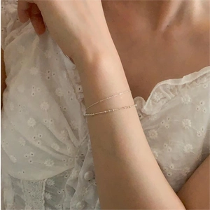 Close-up of elegant double-layered minimalist silver bead bracelet on a woman wrist
