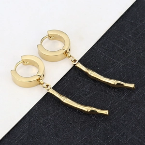 Detail of gold-plated stainless steel hoop earrings featuring minimalist bamboo pendants