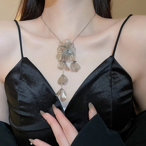 Close-up of silver hollow flower tassel necklace on model with elegant vintage style
