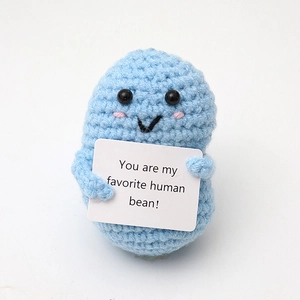 Close-up of blue crochet bean doll holding a card saying You are my favorite human bean