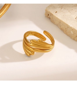 Macro shot of minimalist gold layered wing ring with polished texture on stone base