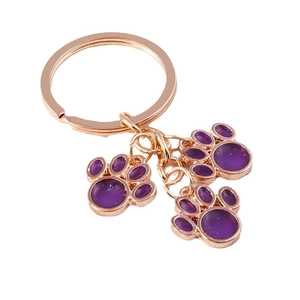 Rose gold cat paw keychain with purple resin pads for backpacks and creative gift usage