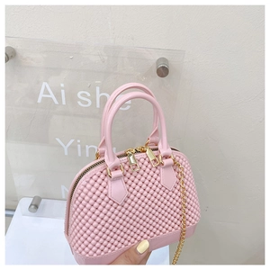 Detailed view of pink shell-shaped PVC bag with unique spherical texture and gold chain