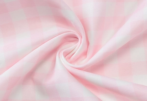 Detailed macro view of soft pink and white plaid fabric texture with natural folds